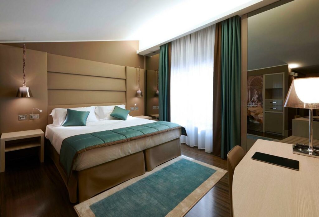 A charming, modernly decorated hotel room with dark green accents.