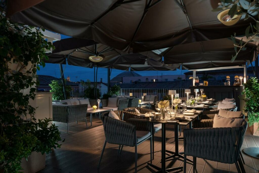 Beautiful rooftop restaurant of the hotel in the evening with set tables.
